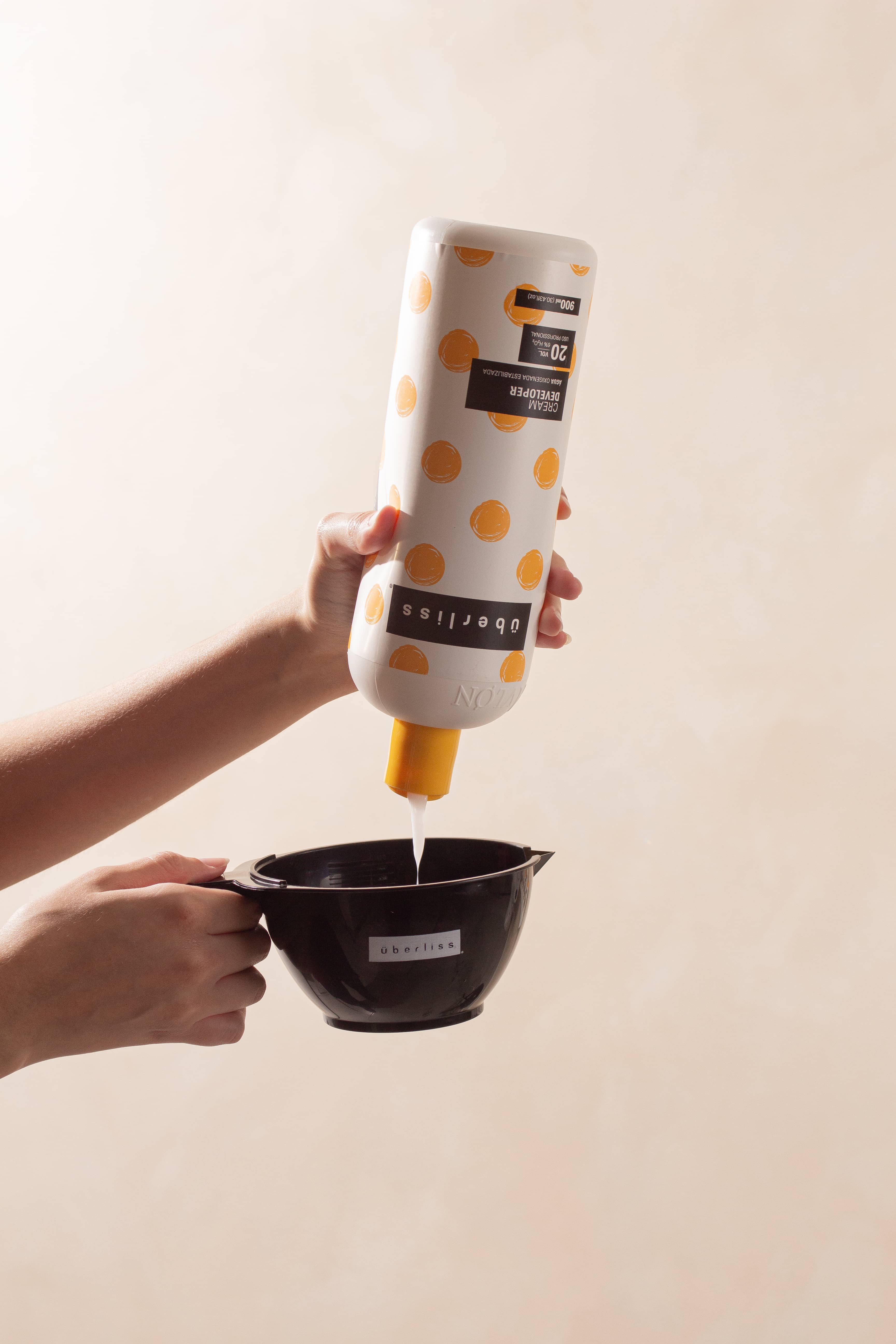 Frasco de água oxigenada estabilizada Überliss para uso profissional, com fórmula suave que minimiza danos durante a descoloração. Ideal para uso com os pós descolorantes da marca.