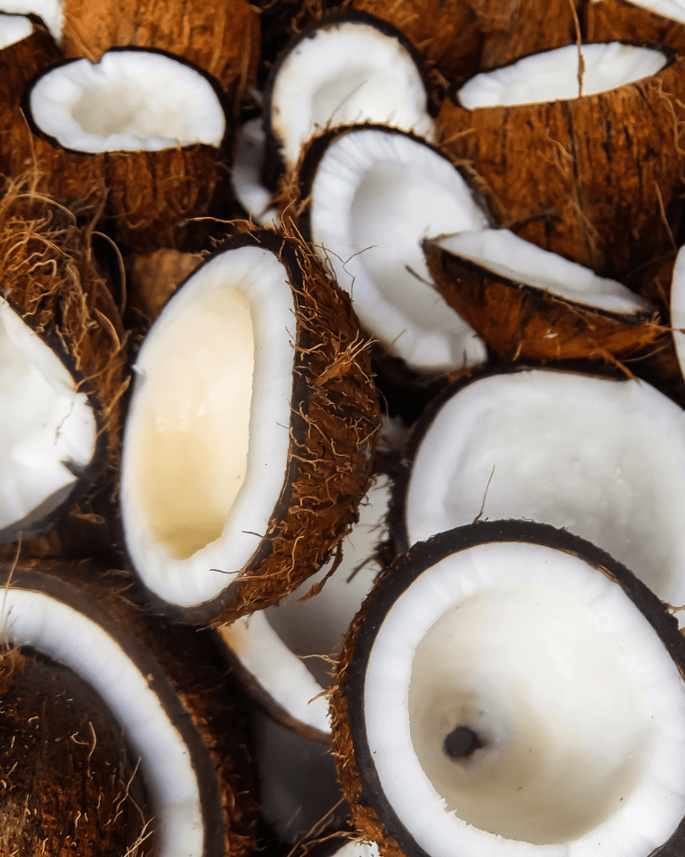 Imagem de óleo de coco puro sendo derramado em uma colher, representando nutrição intensa e hidratação natural para os cabelos.